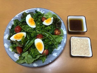 お皿に、レタス、さやえんどう、ミニトマト、4等分にカットされたゆで卵が盛り付けられている写真