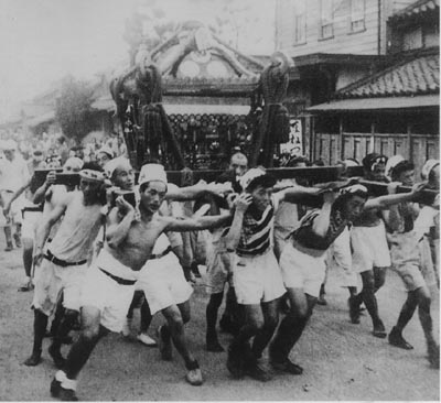 男性の方々が、おみこしを担いでいる幸宮神社の大杉祭り（昭和27年）の白黒写真