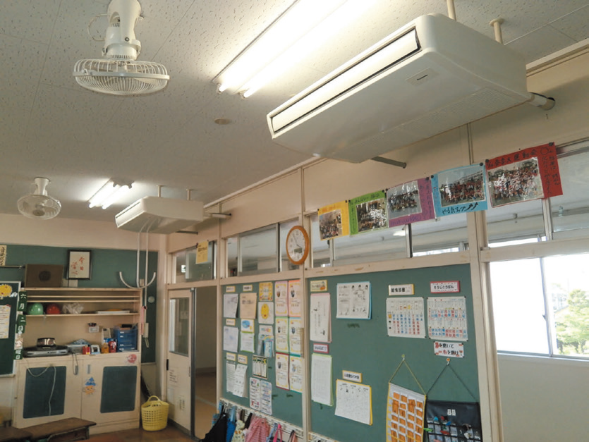 教室の天井に設置されたエアコンと扇風機の写真