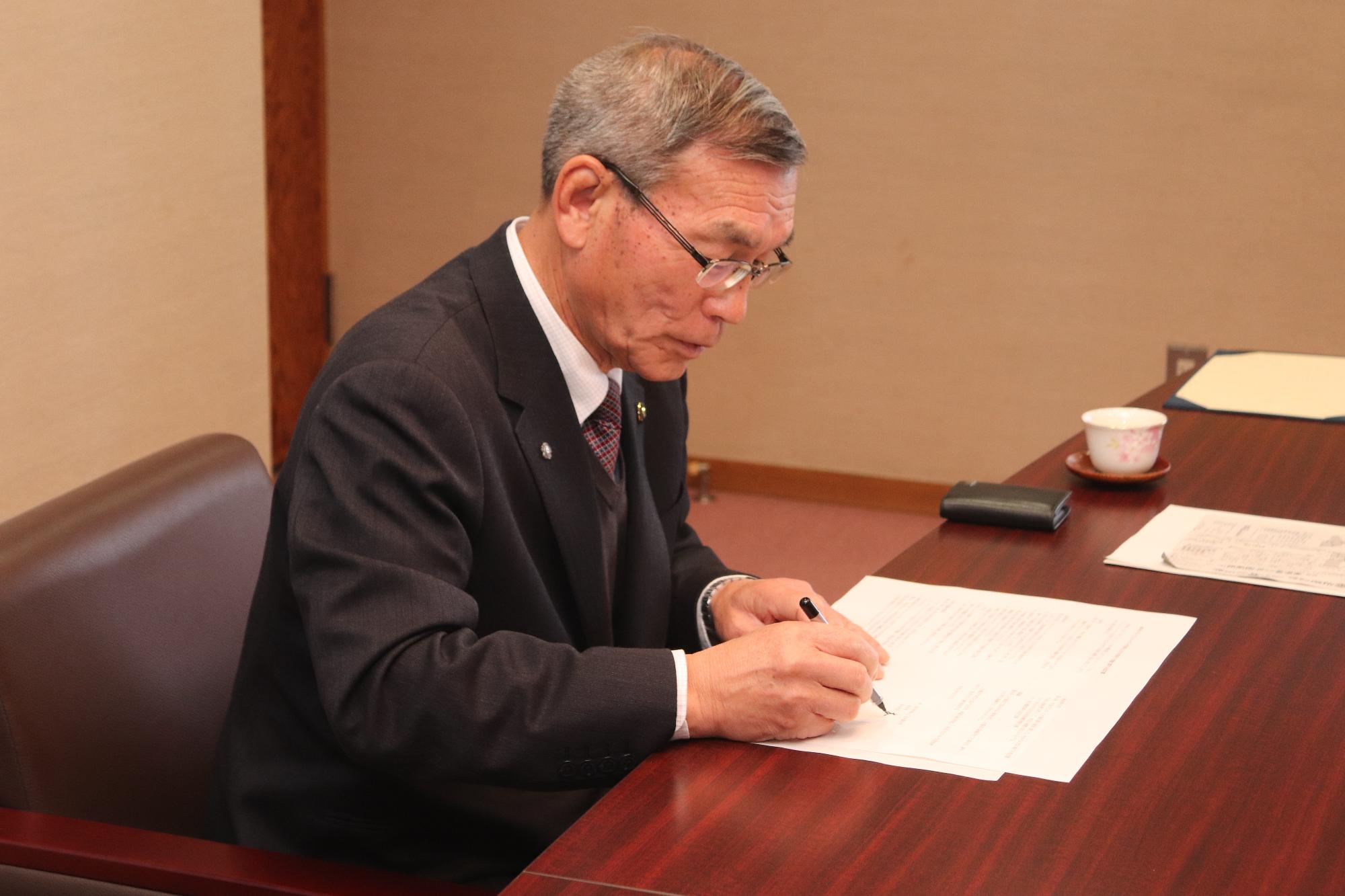 協定書に署名する市長