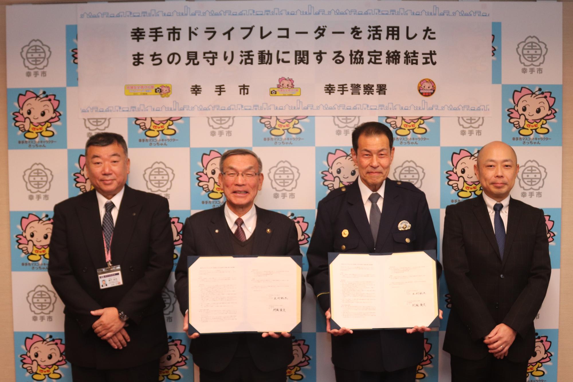 協定書を掲げる市長と幸手警察署長