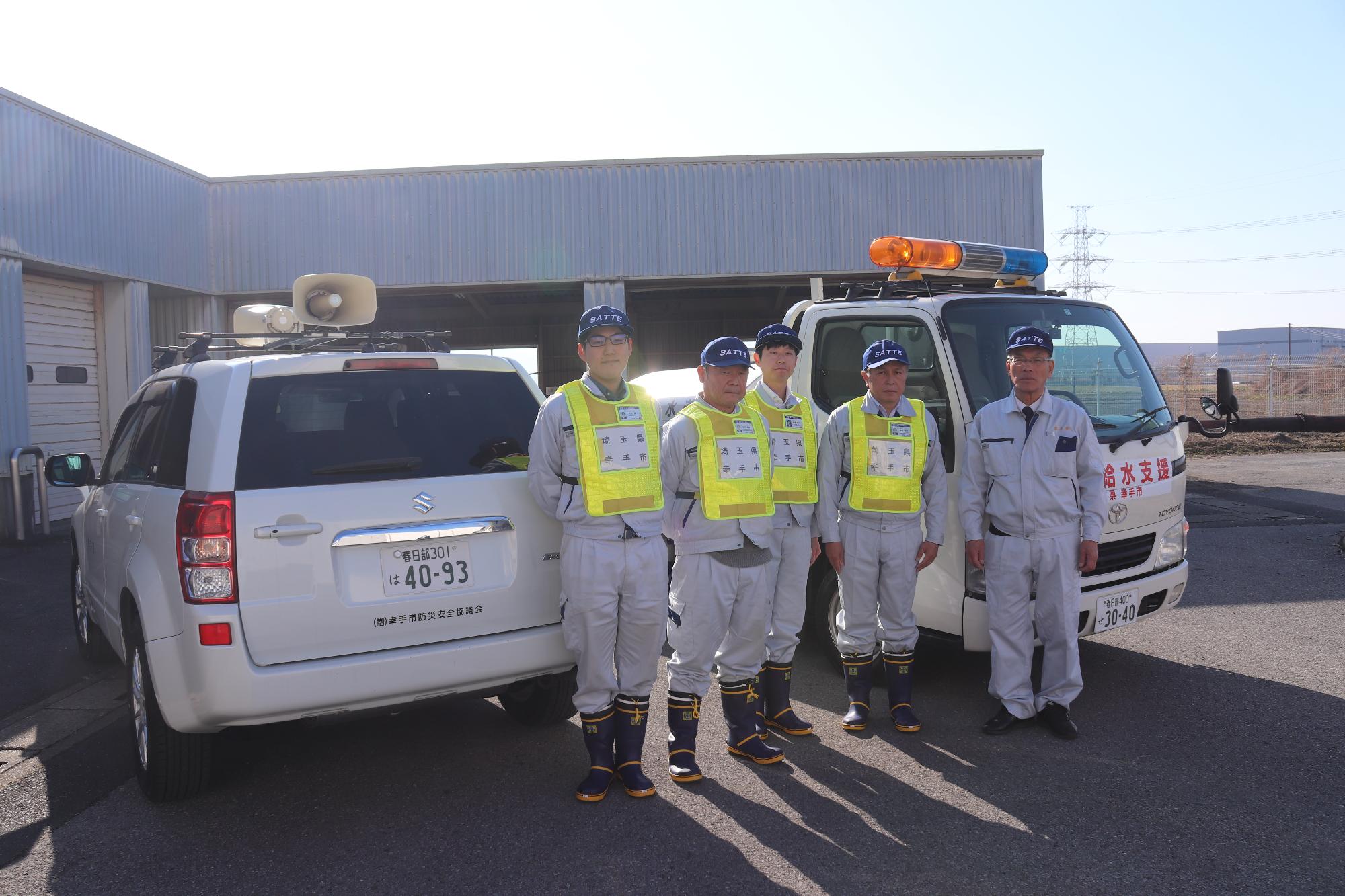 給水車と派遣職員の集合写真